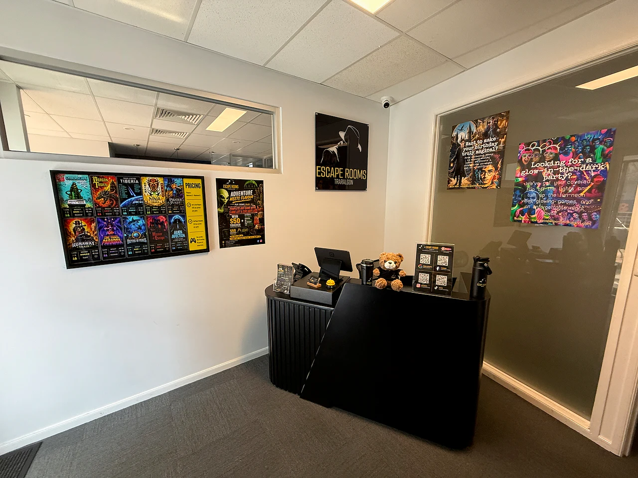 The Escape Rooms Traralgon reception desk with adventure displays on the wall.