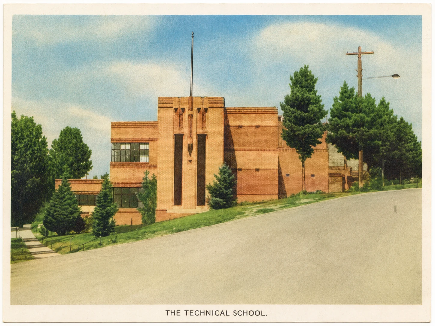 Colour postcard of Yallourn Technical School on a sloping street, retaining its printed lower caption.