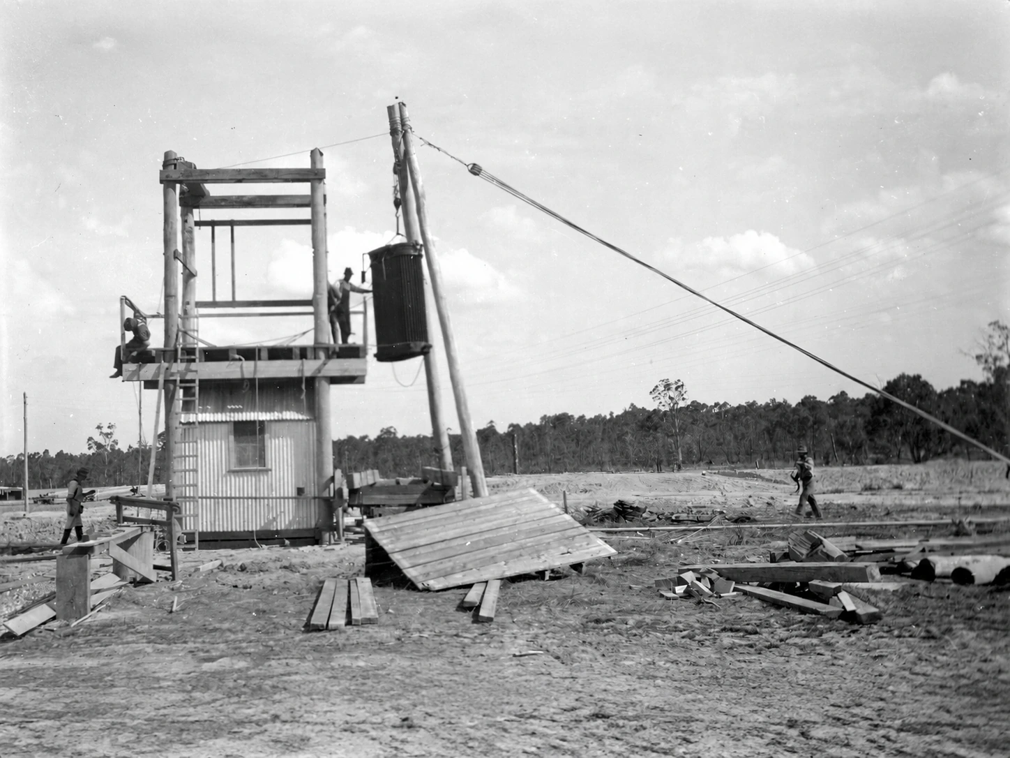 Workers use a pulley and guy line to raise a transformer onto a stand at Yallourn's temporary power plant in 1920.