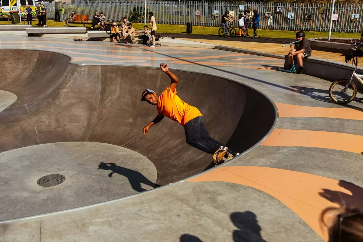 A cyclist moves over a concrete rise at Moe Skatepark while other riders wait nearby.