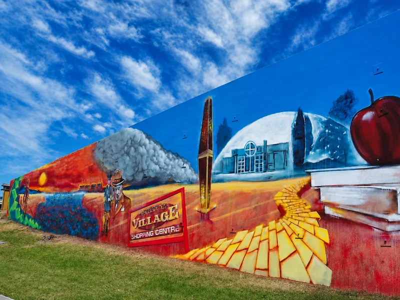 A long Churchill history mural beneath a vivid blue sky.