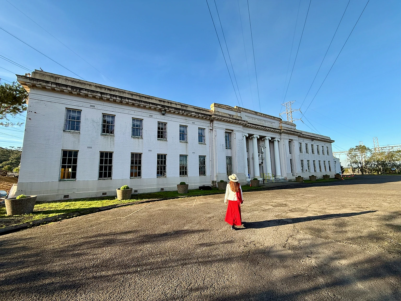 Visitor standing beside the long brick façade of Yallourn Production Centre.