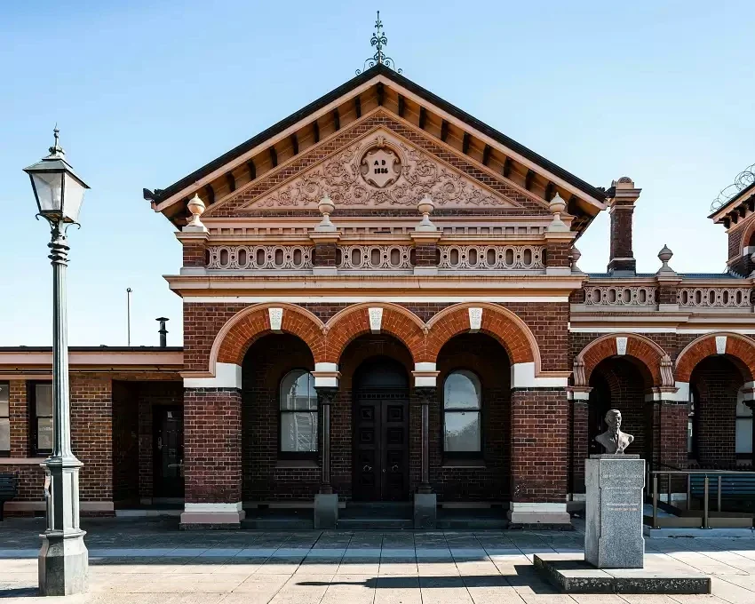 The arched brick facade and ornate gable of Traralgon Courthouse face the civic square.